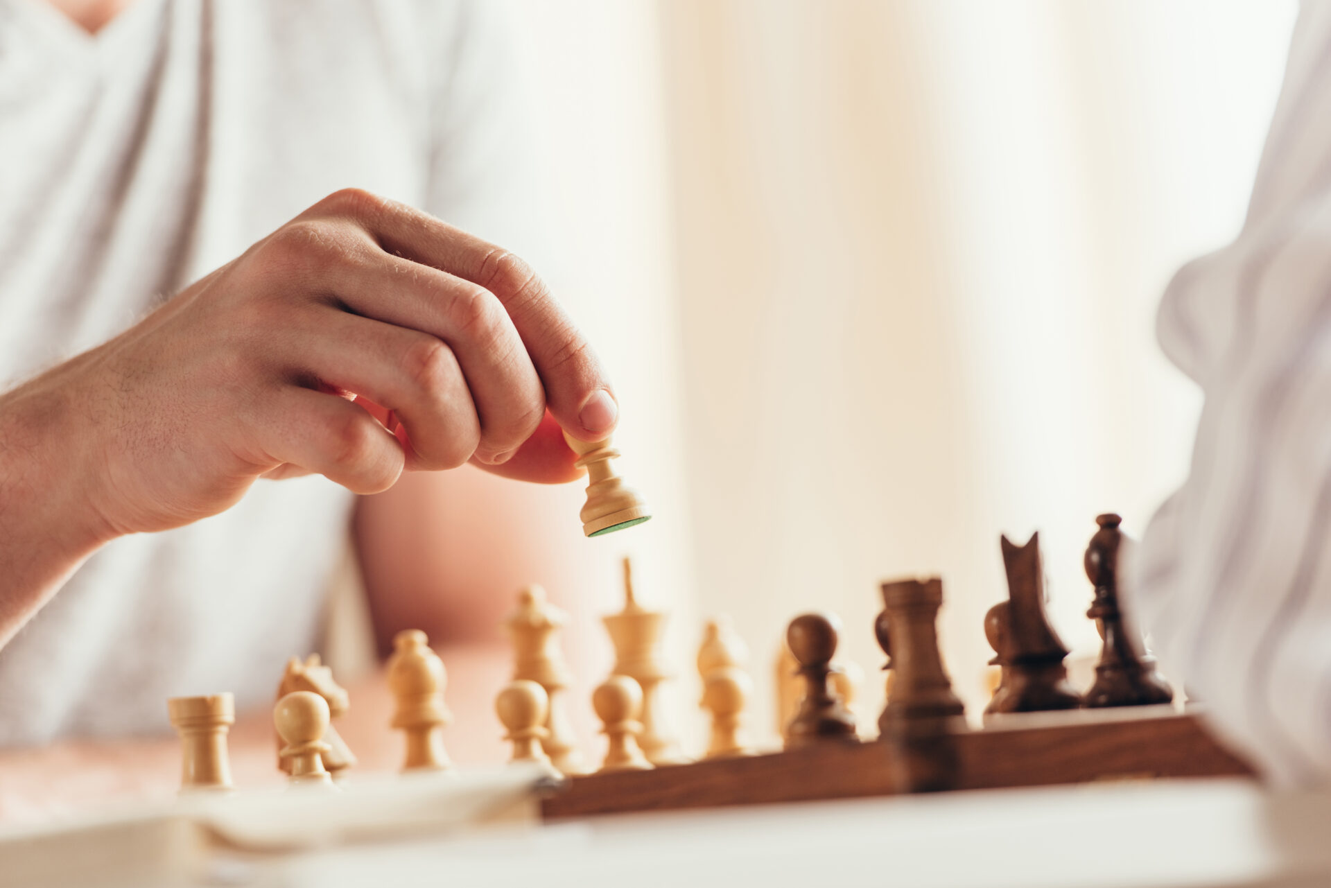 cropped shot of man moving chess figure during game