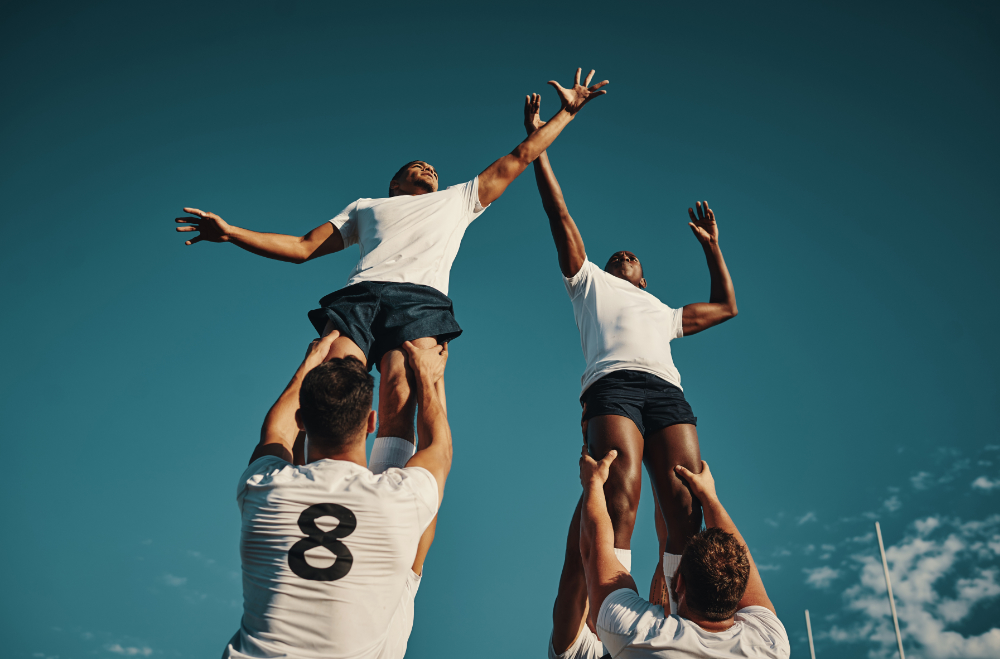 Low angle shot of two handsome young rugby players catching the ball during a lineout on the field.